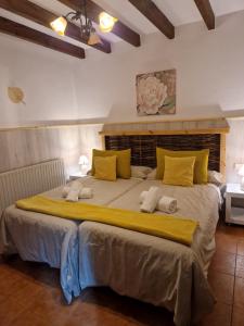 1 dormitorio con 1 cama grande con almohadas amarillas en Apartamentos Rurales El Buxu, en Soto de Cangas