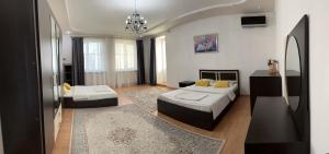 sala de estar con 2 camas y alfombra en Уютная и просторная 3х комнатная в ЦЕНТРЕ, en Uralsk