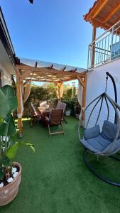 a patio with a hammock and a pergola at Del Sol Suites in Skiathos Town