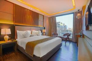 a hotel room with a large bed and a balcony at Hotel Levelup Signature in Amritsar