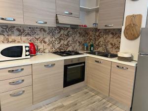 a kitchen with a microwave and a stove top oven at Appartamento Burattino - Immobili e Soluzioni Rent in Bergamo +9 photos