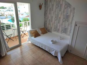 Habitación pequeña con cama y balcón. en Apartamento junto a la playa con terraza y piscina en Cala en Blanes