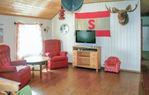 uma sala de estar com televisão e cadeiras vermelhas em Lovely Home In Farsund With Wi-fi em Farsund