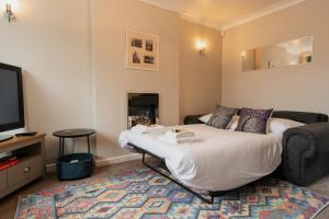 a living room with a bed and a tv at Chester Greenway House - Ideal 1 Bedroom Home, EV Charger & Parking - Sleeps 4 in Chester