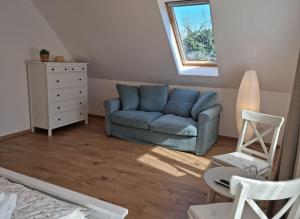 - un salon avec un canapé bleu et une fenêtre dans l'établissement Cottage im Natur-Resort Pool, Schwimmteich & Sauna, à Kiskunmajsa