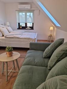 - un salon avec un canapé et un lit dans l'établissement Cottage im Natur-Resort Pool, Schwimmteich & Sauna, à Kiskunmajsa