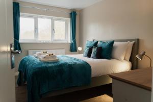a bedroom with a bed with a blue blanket and a window at Chester Greenway House - Ideal 1 Bedroom Home, EV Charger & Parking - Sleeps 4 in Chester