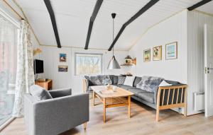 ein Wohnzimmer mit einem Sofa und einem Tisch in der Unterkunft Amazing Home In Oksbl With 3 Bedrooms And Wifi in Oksbøl