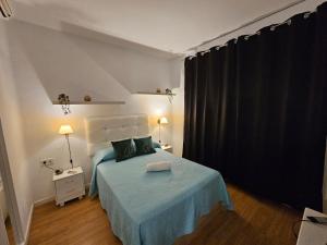 - une chambre avec un lit et une couverture bleue dans l'établissement Apartamento Gran Via Madrid W8.1, à Madrid