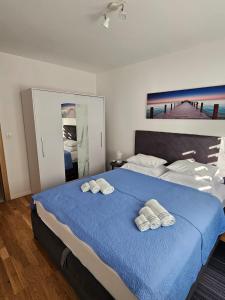 a bedroom with a large blue bed with towels on it at Split/Podstrana Apartment ADRIA in Podstrana