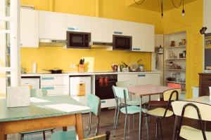uma cozinha com armários brancos e uma mesa e cadeiras em Ostello Bello Lake Como em Como