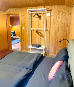 Habitación con cama en una pared de madera. en Charming, well-equipped Alpine apartment en Kandersteg