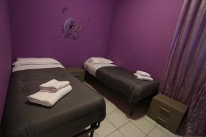 duas camas num quarto com paredes roxas em House 27 em Fiumicino