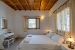 a bedroom with a bed and a sink and a window at Maria's Village Two Bedroom House 1 in Aliki