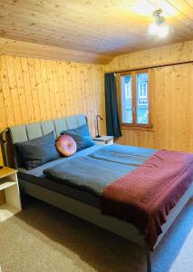 1 dormitorio con 1 cama en una habitación de madera en Charming, well-equipped Alpine apartment en Kandersteg