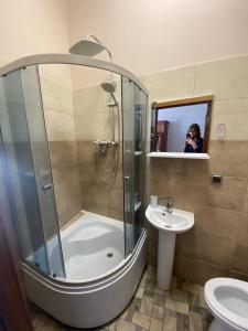 a woman taking a picture of a shower in a bathroom at Апартаменти на вулиці Залізняка - бічна вулиці Антоновича in Lviv