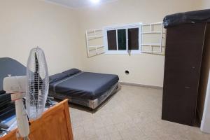 Cette chambre comprend un lit, un ventilateur et une fenêtre. dans l'établissement Casa Quinta El Romance 5100m2, à La Reja