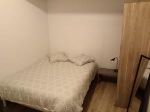 ein kleines Schlafzimmer mit einem Bett und einer Lampe in der Unterkunft Appartement T2 privé proche gare in Marseille