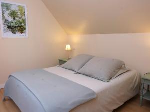 een bed in een kamer met twee tafels en een foto aan de muur bij Maison près de la plage et de la thalasso in Roscoff