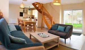a living room with a couch and chairs and a table at Maison près de la plage et de la thalasso in Roscoff