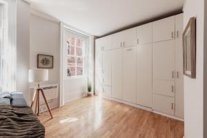 an empty living room with white cabinets and a couch at Covent Garden Stay in London