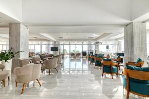 a lobby with chairs and tables in a building at Atlantica Sea Breeze, Adults Only in Protaras