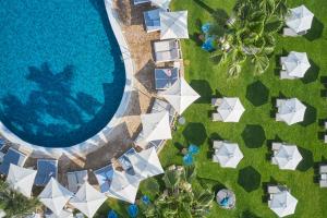 een uitzicht over het zwembad van een resort met witte parasols bij Atlantica Sea Breeze, Adults Only in Protaras