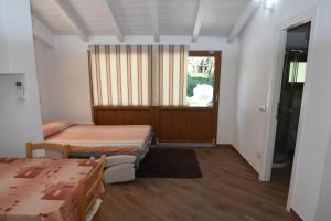 a room with two beds and a table and a window at Villetta Orchidea - Indipendente con giardino privato in Marina di Campo