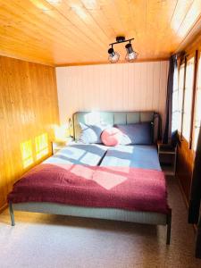 1 dormitorio con 1 cama con manta roja en Charming, well-equipped Alpine apartment en Kandersteg