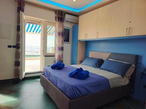 a bedroom with a bed with blue pillows on it at A terrace on the sea in Maiori