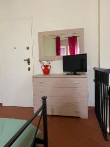 a bedroom with a dresser with a television on it at L'orologio matto in Marina di Carrara