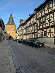 une rangée de voitures garées devant un bâtiment dans l'établissement Ambiente am Breiten Tor Apartment 1, à Goslar