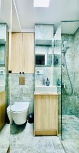 a bathroom with a toilet and a sink and a shower at Cosy Stay Muranów in Warsaw