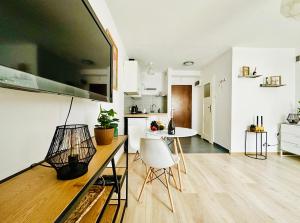 a kitchen and living room with a table and chairs at Cosy Stay Muranów in Warsaw
