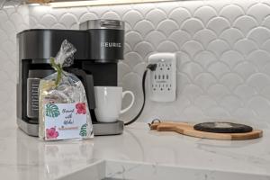 una cafetera en un mostrador junto a una taza en Fully Remodeled Ocean Front Comfort HKOK316, en Kihei
