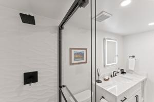 Un baño blanco con ducha y lavabo. en Fully Remodeled Ocean Front Comfort HKOK316, en Kihei 39 fotos más