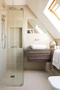 a bathroom with a glass shower and a sink at Central Chichester 3bd Mews House For Up To 6 in Chichester