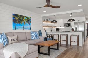 Una sala de estar y una cocina con un sofá y una mesa. en Fully Remodeled Ocean Front Comfort HKOK316, en Kihei