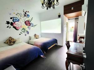 台東市的住宿－台東 夢之谷 l 寵物友善 l 停車場，卧室配有两张挂有鲜花的床。