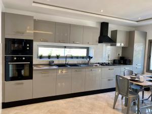 a kitchen with white cabinets and a table and a dining room at 3 pieces lumineux avec balcon in Sidi Bou Saïd