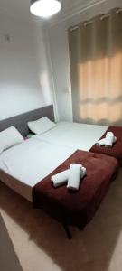 1 dormitorio con 2 camas y toallas blancas. en Vive Huelva ARAGON 4 HABITACIONES WIFI 300MB en Huelva