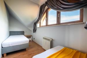 une chambre avec deux lits et une grande fenêtre dans l'établissement Dom nad jeziorem Morenowe Wzgórze, à Płociczno 36 autres photos