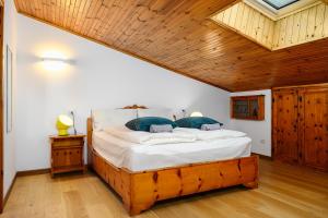 a bedroom with a large bed with a wooden ceiling at A Casa dell'Orso in Bormio