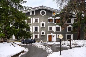 a house with a car parked in front of it in the snow at A Casa dell'Orso in Bormio