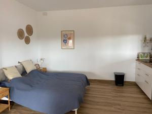 een slaapkamer met een blauw bed en een witte muur bij Hacienda Donaire Beas in Beas