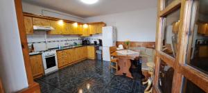 a kitchen with wooden cabinets and a white refrigerator at Csongor Vendégház in Bogács