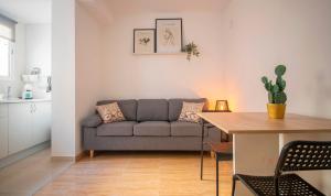 ein Wohnzimmer mit einem Sofa und einem Tisch in der Unterkunft TarracoHomes-TH08 Apartamento con patio privado en el centro de Tarragona in Tarragona