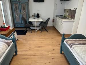 Zimmer mit 2 Betten, einem Tisch und einer Küche in der Unterkunft Gemütliches Eifeler Gästehäuschen in Nettersheim