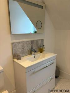 a bathroom with a sink and a mirror at Annie’s Flat in Aberfeldy