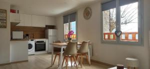 a kitchen with a table and chairs in a room at Appartement cosy au coeur du Mercantour in Valdeblore +10 photos